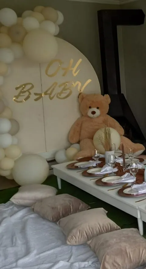 Neutral baby shower setup with balloons and teddy bear
